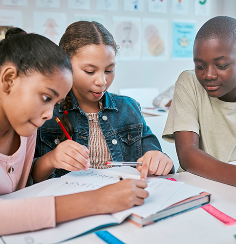Image shows three students studying at a table.