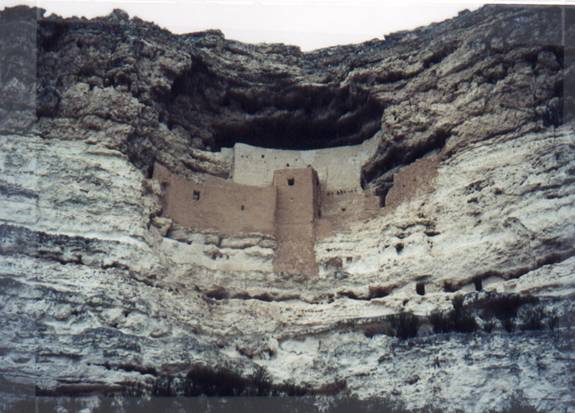 This a color picture of a home carved into cliff.